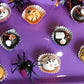 Halloween-themed cupcakes / oat ball on a purple tray with decorative spiders.
