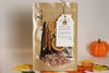 Pouch of potpourri with a tag on a neutral background with a pumpkin and leaves.