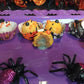 Halloween-themed oozing cupcakes / oat balls and decorative spiders on a purple surface